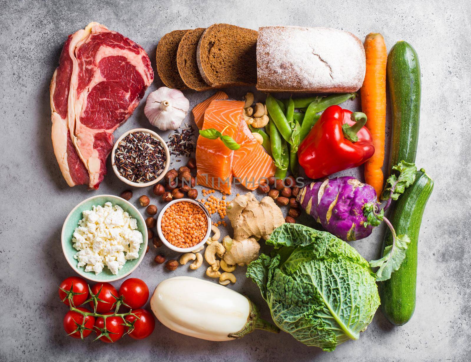 Assortment of healthy balanced food composition: meat, fish, vegetables, bread, cereals, beans, stone background. Raw ingredients for cooking healthy meal, good for diet, clean eating concept