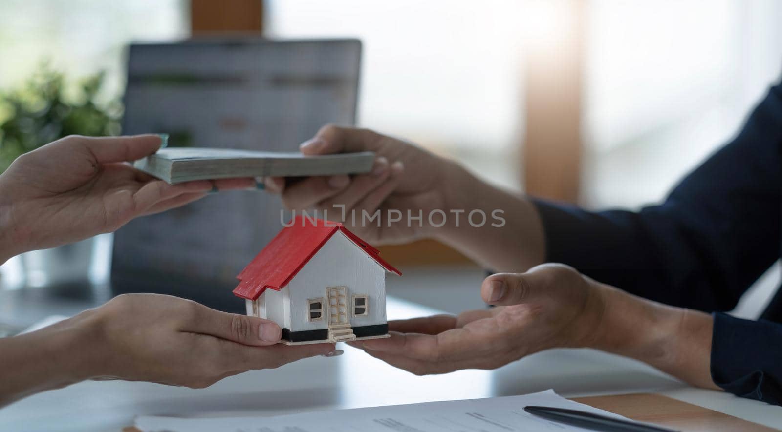 A professional female real estate agent receives a house loan payment or rent fee from her client. Property investment concept. cropped image.A professional female real estate agent receives a house loan payment or rent fee from her client. Property investment concept. cropped image.