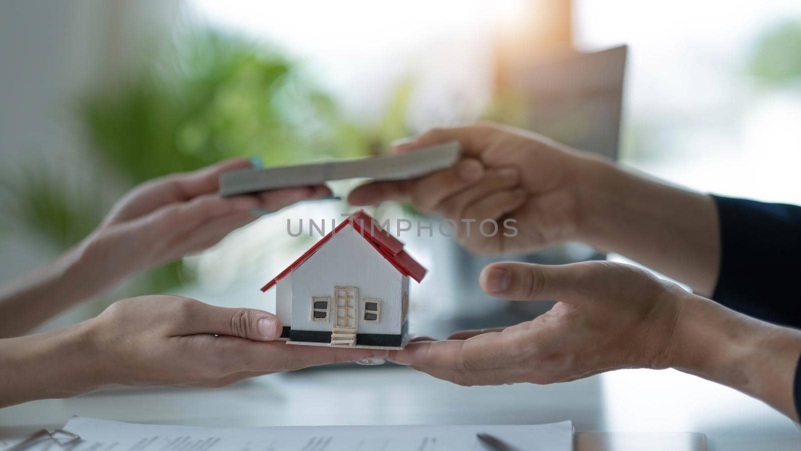 A professional female real estate agent receives a house loan payment or rent fee from her client. Property investment concept. cropped image.