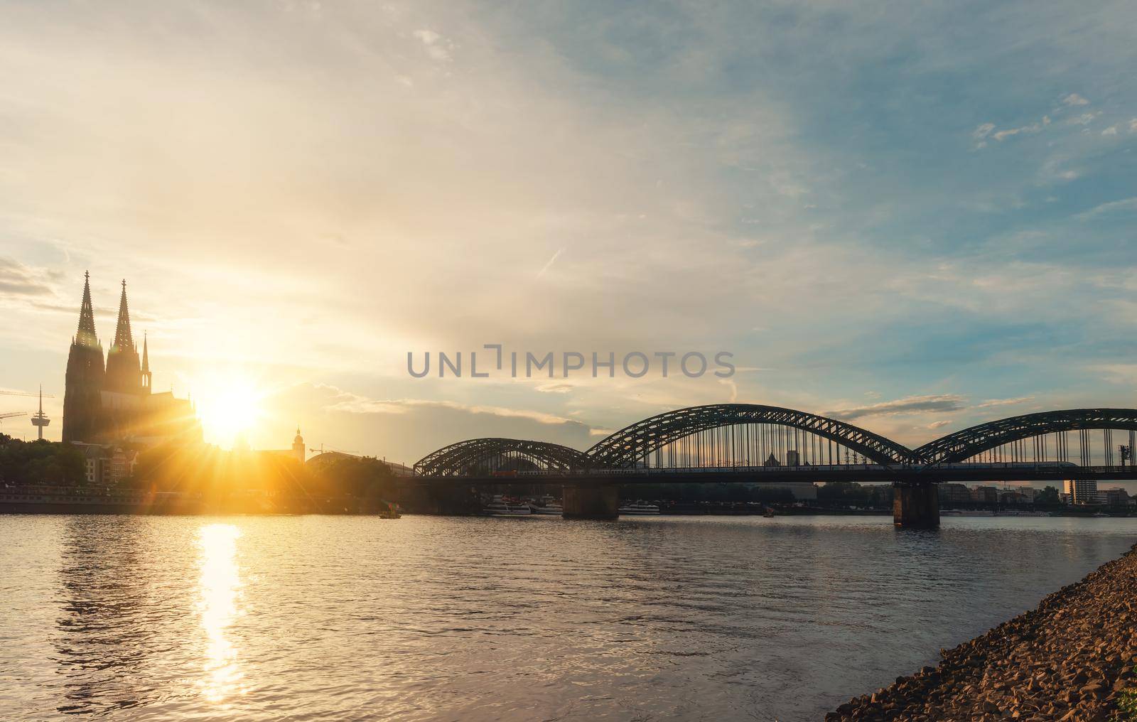 GERMANY, COLOGNE- JUNE, 24, 2022: THE RHINE EMBANKMENT embankment of Rhine on background of Cologne Cathedral and Hohenzollern Bridge in Cologne Koel, Germany at sunset. Tourism and travel by Germany.. by Iryna_Melnyk