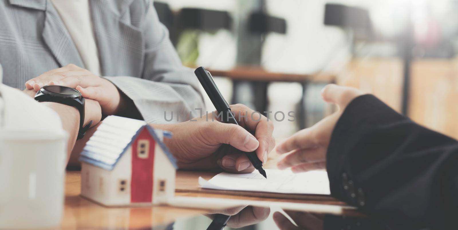 A lovely couple in the meeting with their real estate agent to sign the house contract. Property investment concept. cropped image.