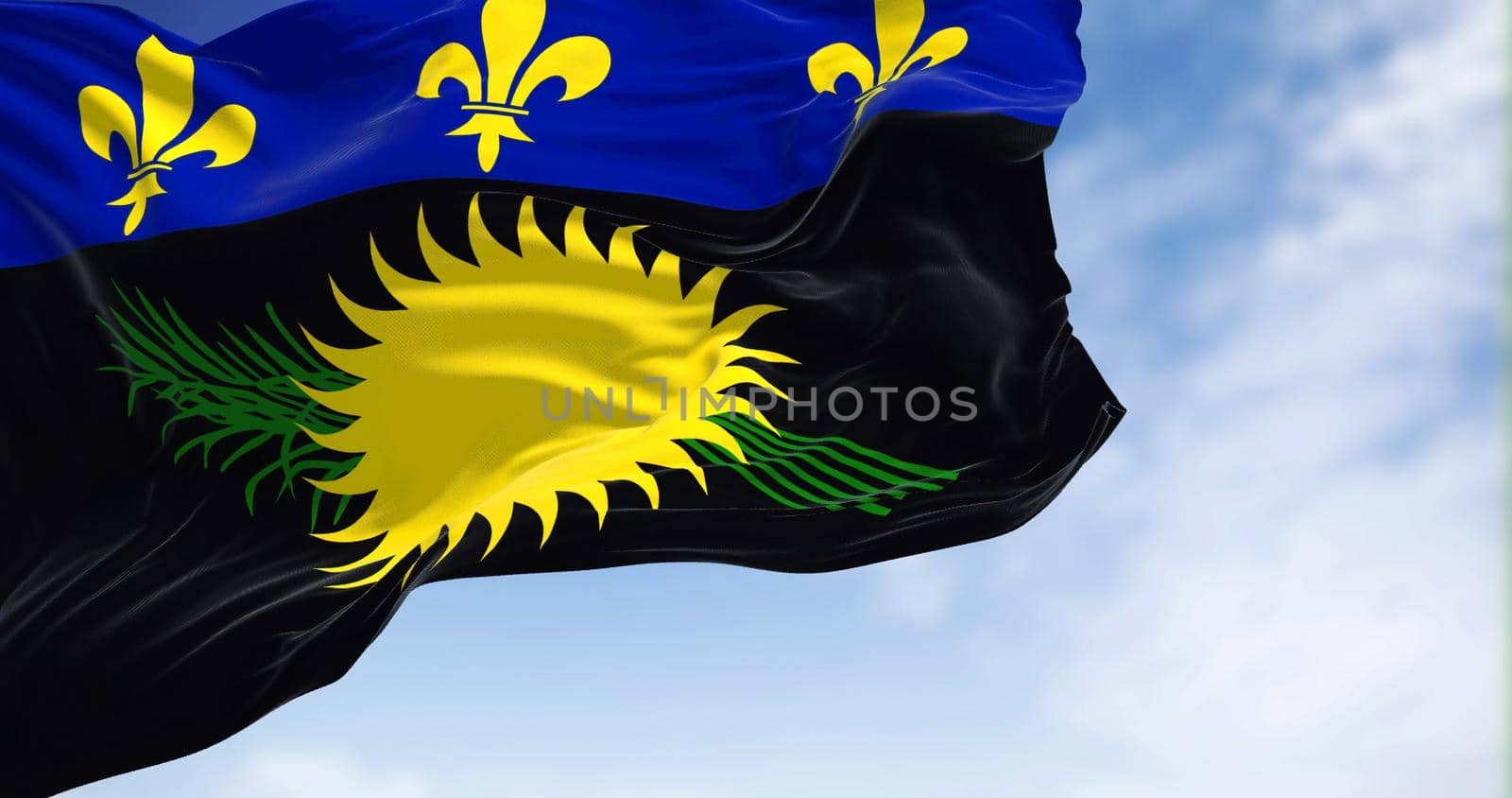 Flag of Guadeloupe waving in the wind on a clear day. Guadeloupe is an archipelago and overseas department and region of France in the Caribbean
