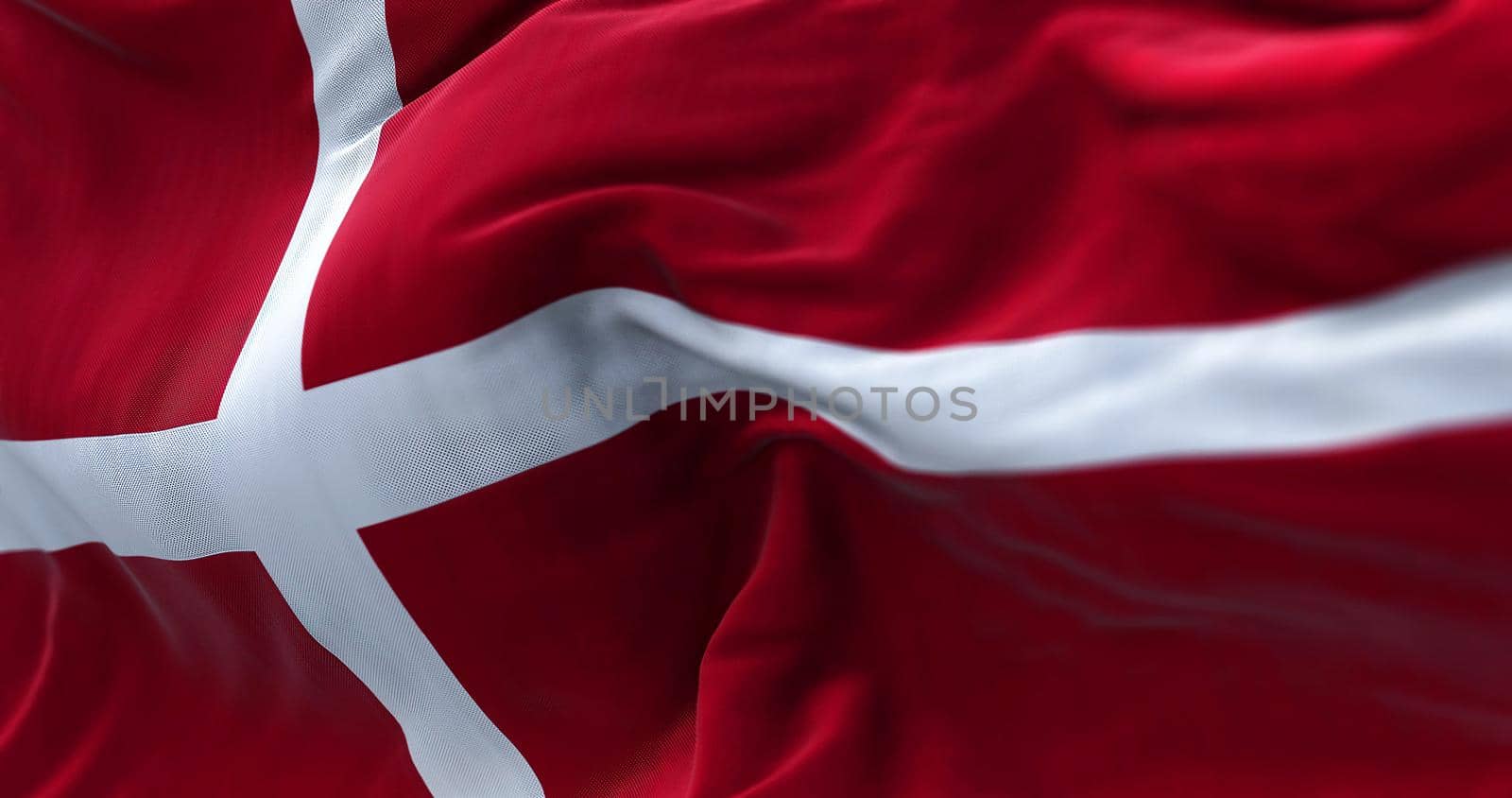 Close-up view of the Denmark national flag waving in the wind. Denmark is a Nordic country in Northern Europe. Fabric texture background. Selective focus