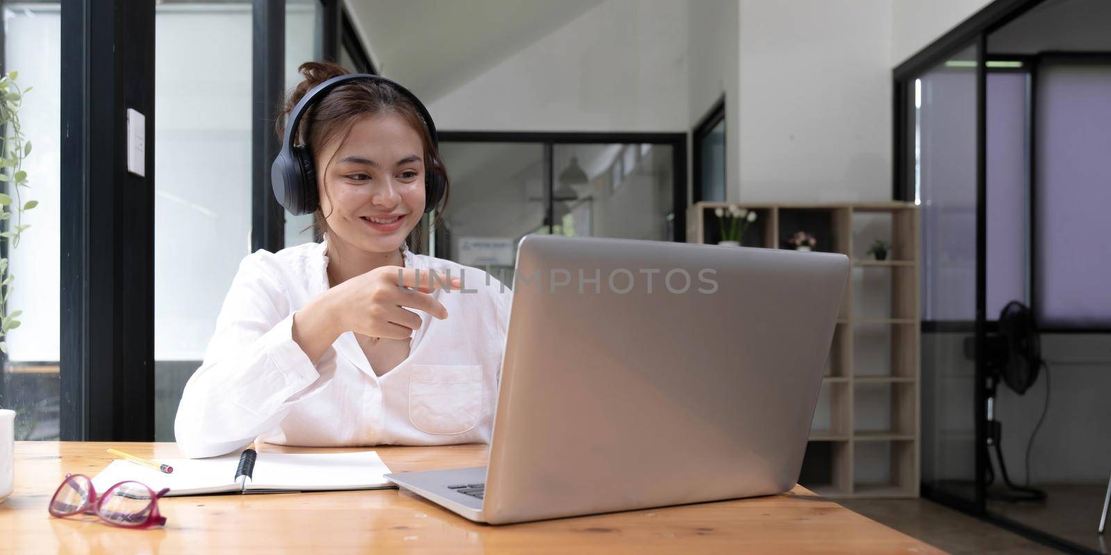 close up of Student learning online class by using laptop computer and writing notebook at workplace, E learning and online working concept. by wichayada