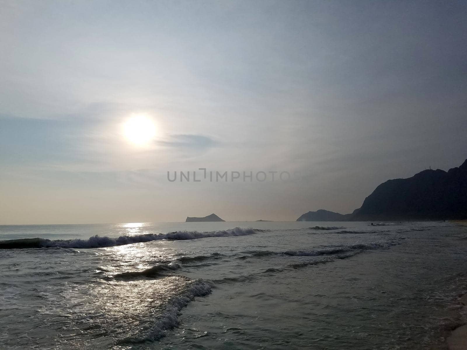 Early Morning Sunrise on Waimanalo Beach on Oahu, Hawaii with Rabbit and Rock Island on the horizon on a cloudy voggy day. October 1, 2017.