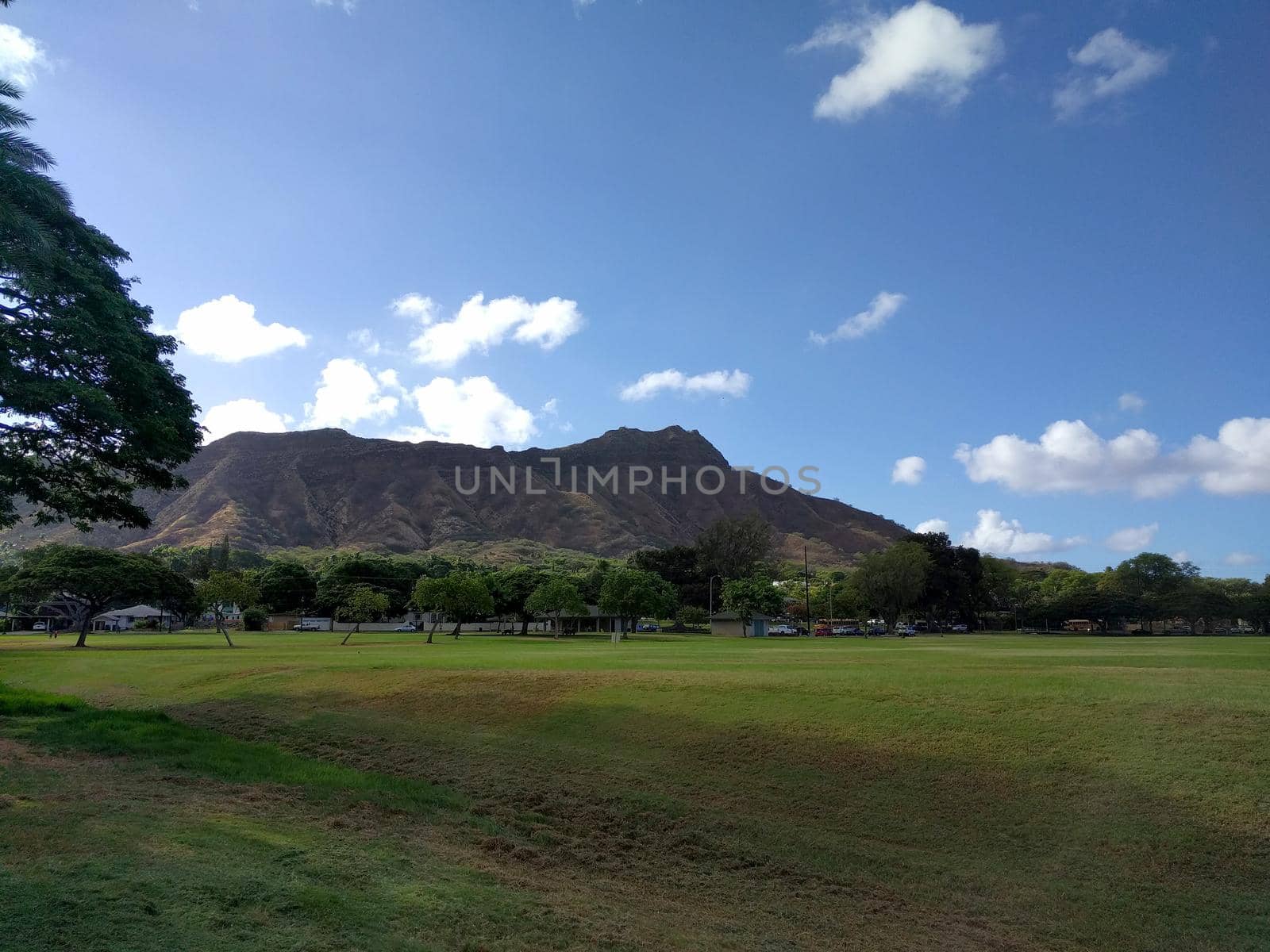 Kapiolani Park at during day with Diamond Head and clouds in the distance on Oahu, Hawaii.