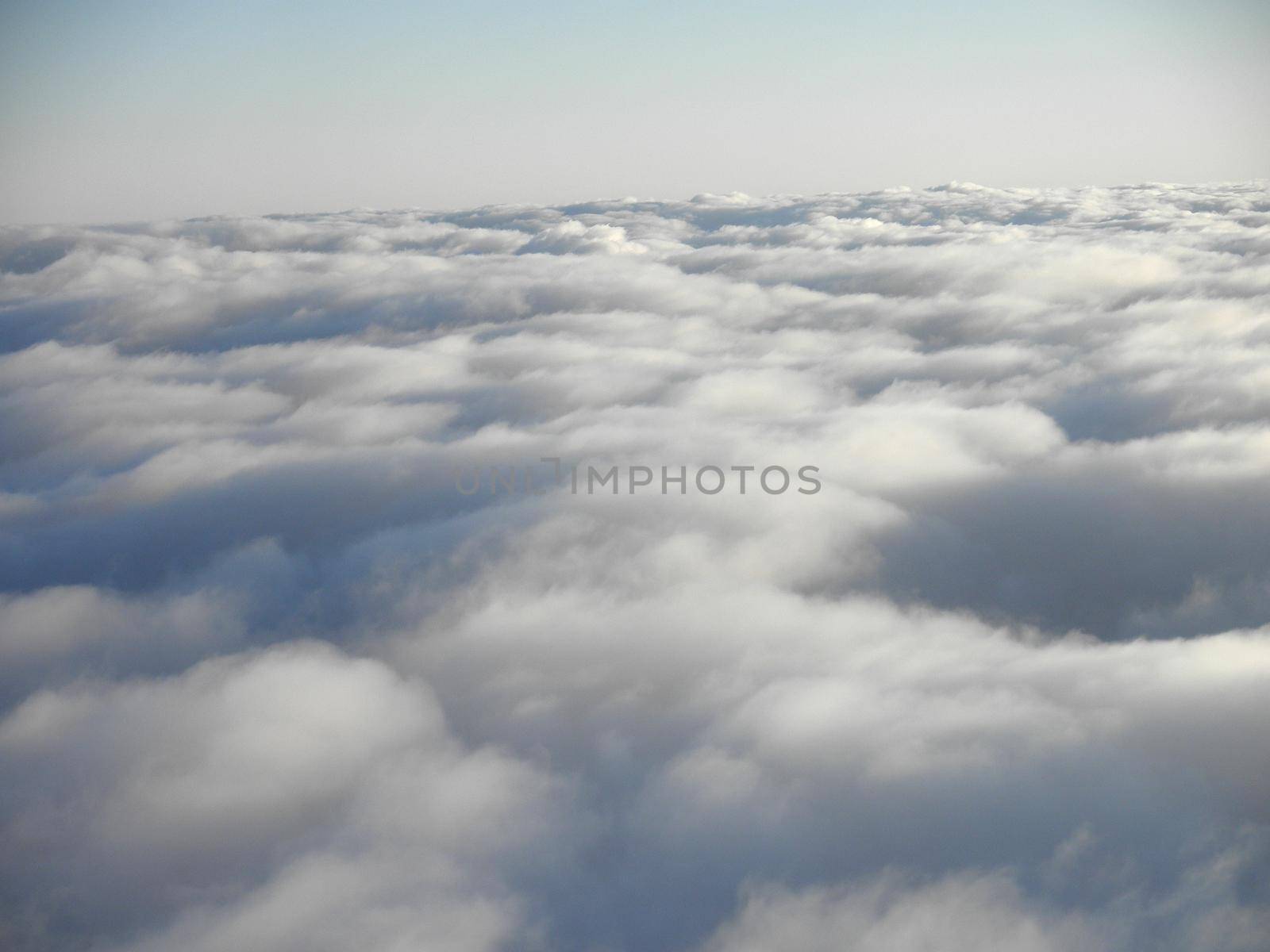 floating above and on top of fluffy curvy clouds as far as the eye can see