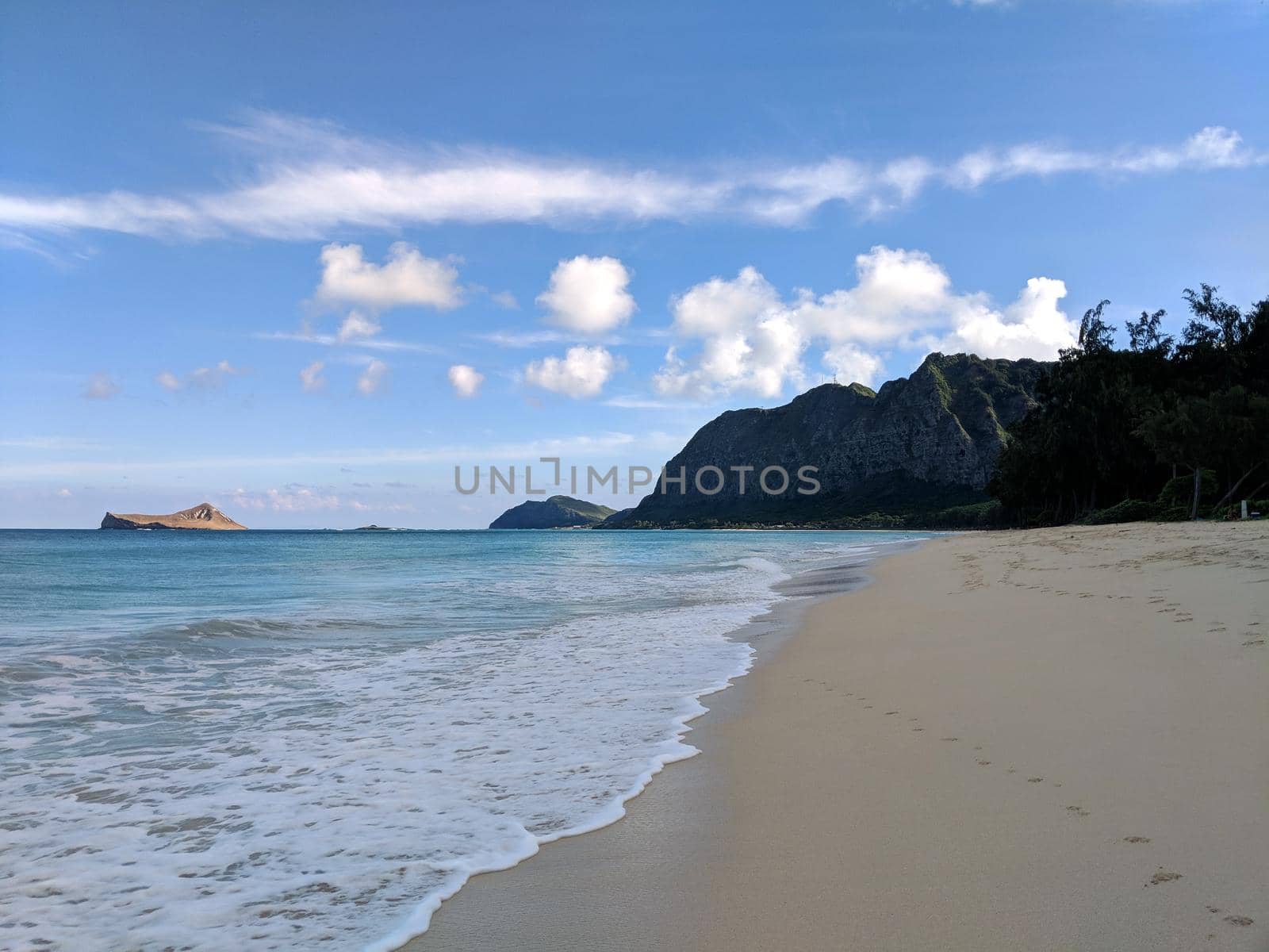 Gentle wave lap on Waimanalo Beach looking towards Rabbit island and Rock island on a nice day Oahu, Hawaii.  December 11, 2017.