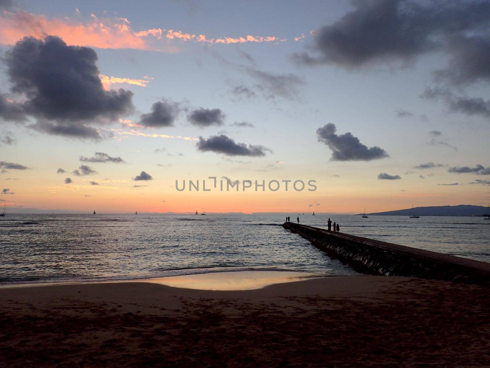 Rock Pier leading into Pacific ocean at dusk by EricGBVD