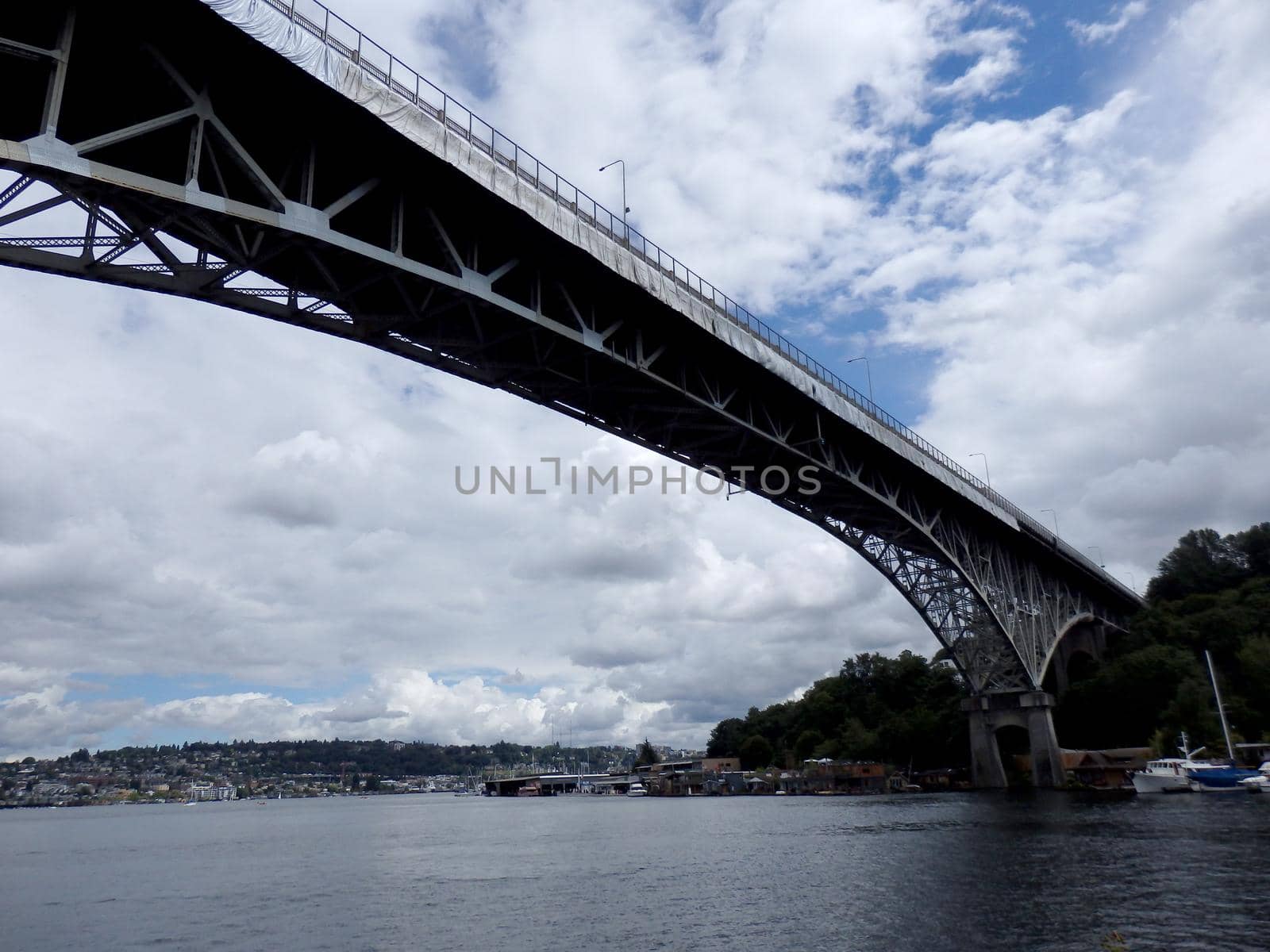 Aurora Bridge, under repair, towers over Union Lake with boats lining the shore in Seattle, Washington.