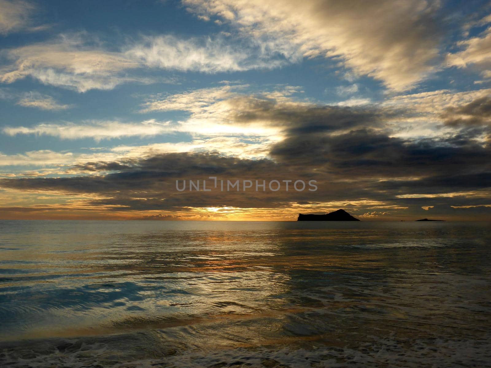 Early Morning Sunrise on Waimanalo Beach on Oahu, Hawaii by Rabbit and Rock Island through the clouds. 2018.