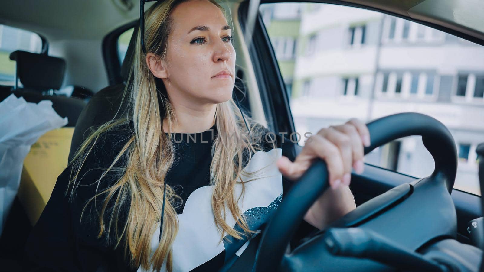 A young woman driving a car is driving on the highway