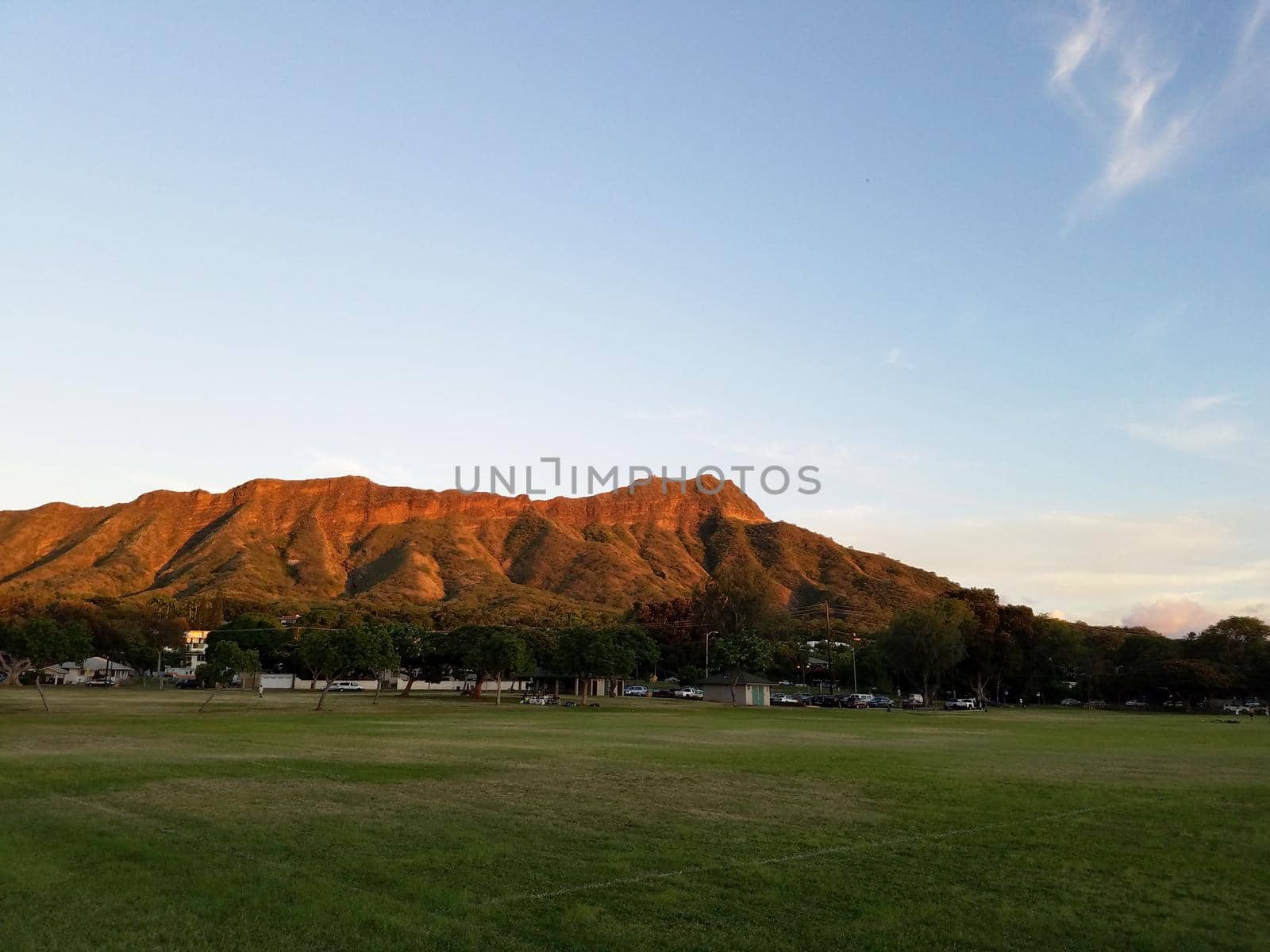 Kapiolani Park at dusk with Diamond Head and clouds in the distance on Oahu, Hawaii.