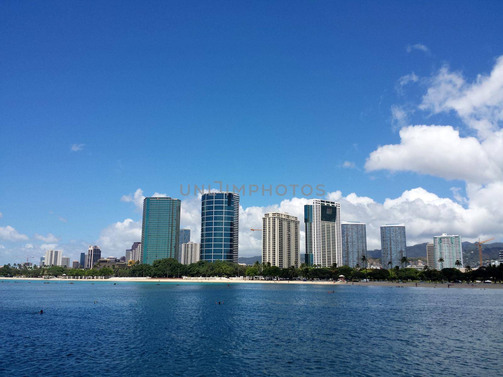 Ala Moana Beach Park with office building and condos in the background during a beautiful day on the island of Oahu, Hawaii. September 18, 2013.