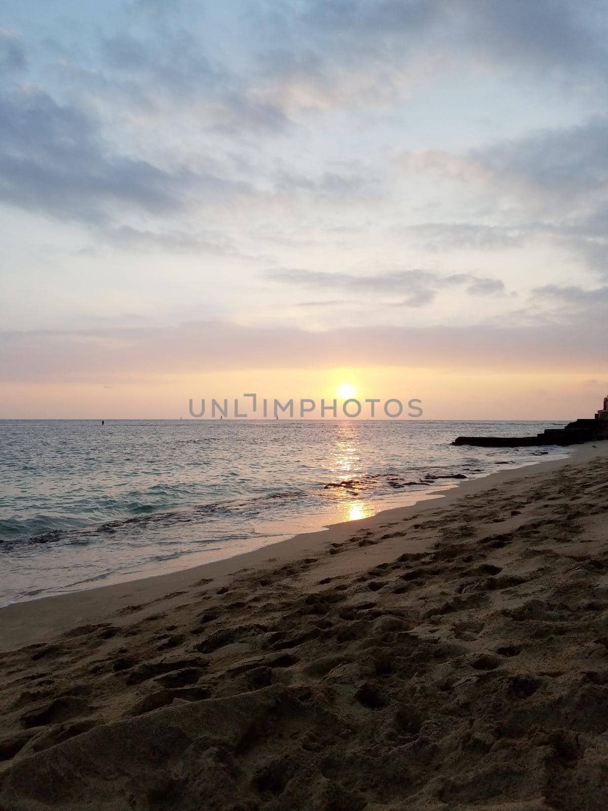 Sunsets over Waikiki waters as waves roll into shore at Makalei Beach Park by EricGBVD