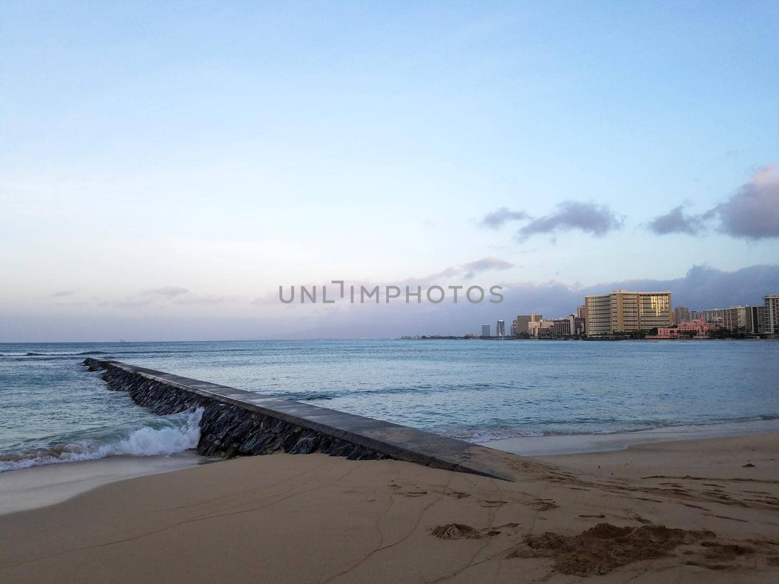 Rock Pier leading into Pacific ocean at dusk off the coast of Waikiki by EricGBVD