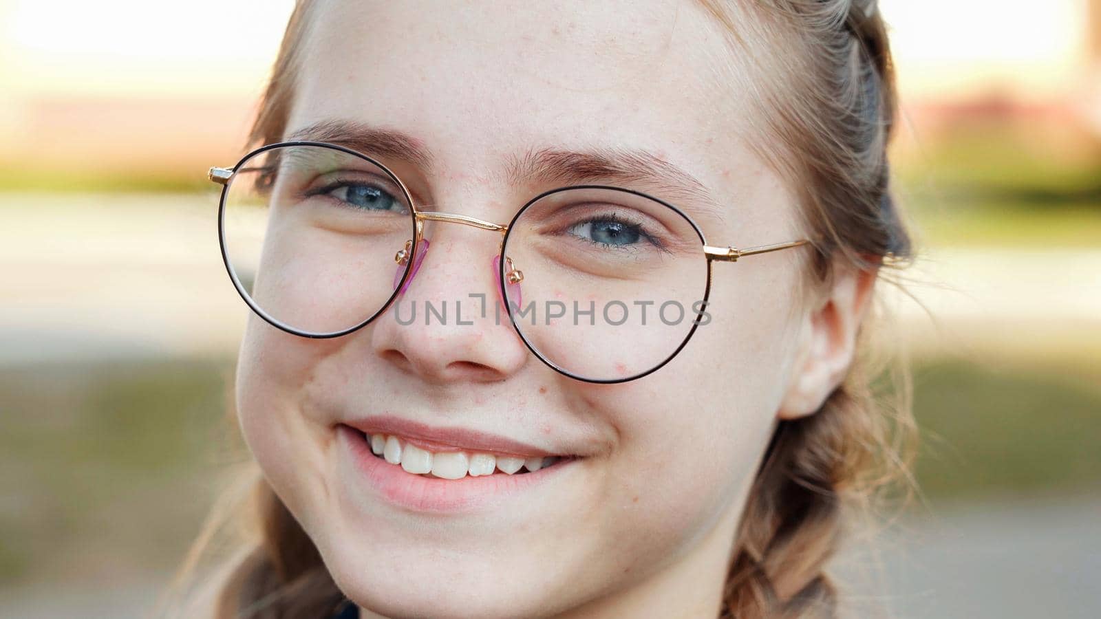 A teenage girl wearing glasses. Close-up of her face