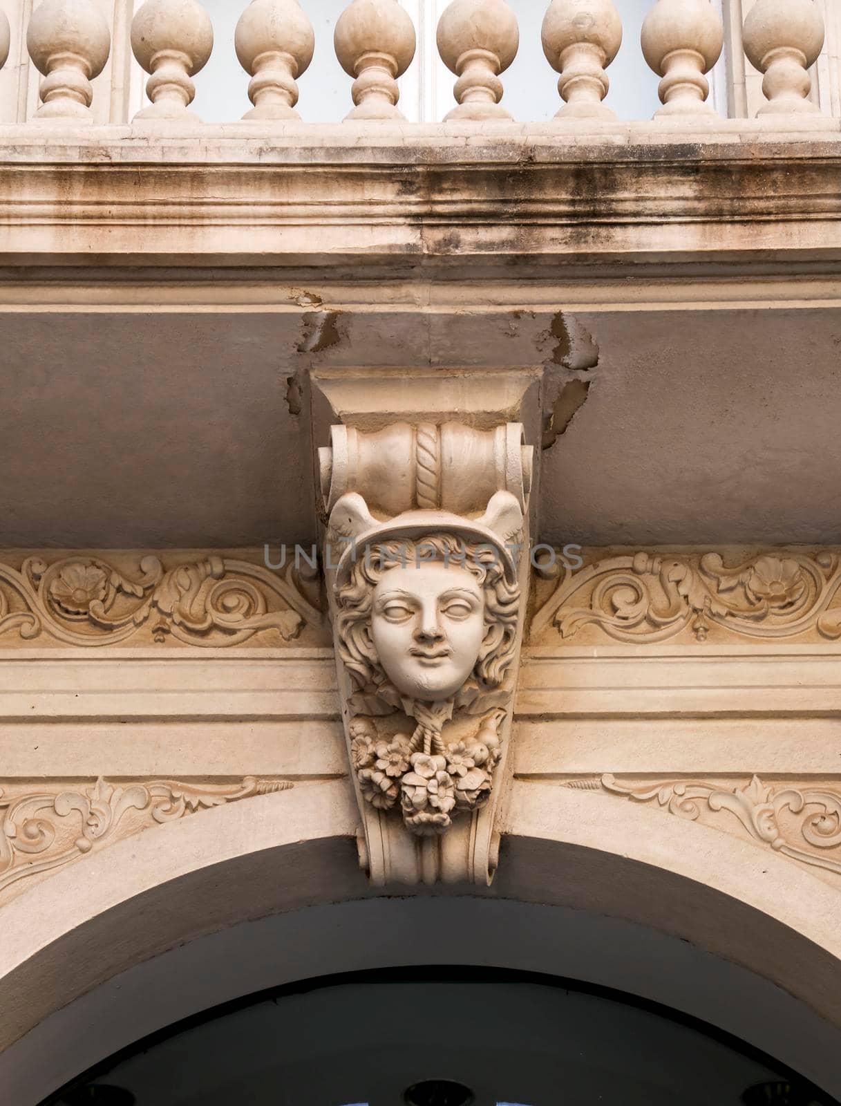 Carved stone woman face on a facade of modernist building in Cartagena, Spain
