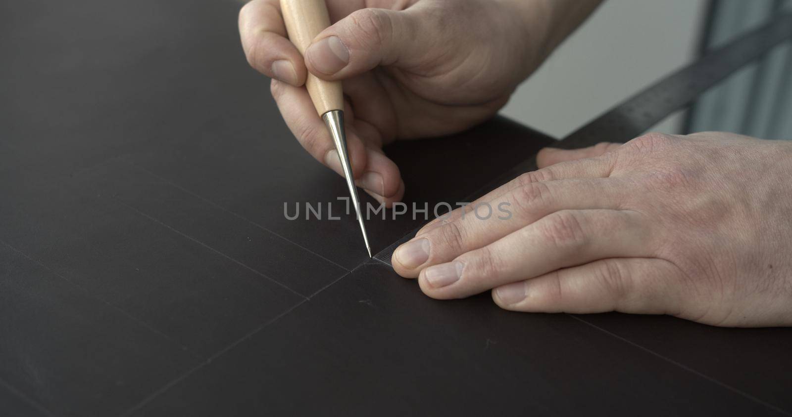 Working process of crafting a bew handmade leather wallet in the leather workshop. Concept of small business to create leather products. Horizontally framed shot. by vovsht