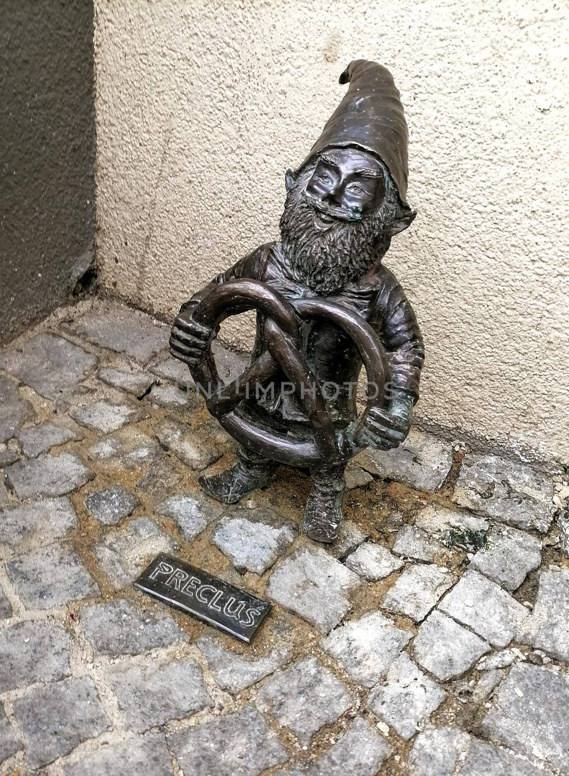 Dwarf gnomes sculpture with magnifying glass in downtown of famous polish city. Wroclaw Houses and streets of the city of Wroclaw. Cityscape. High quality photo