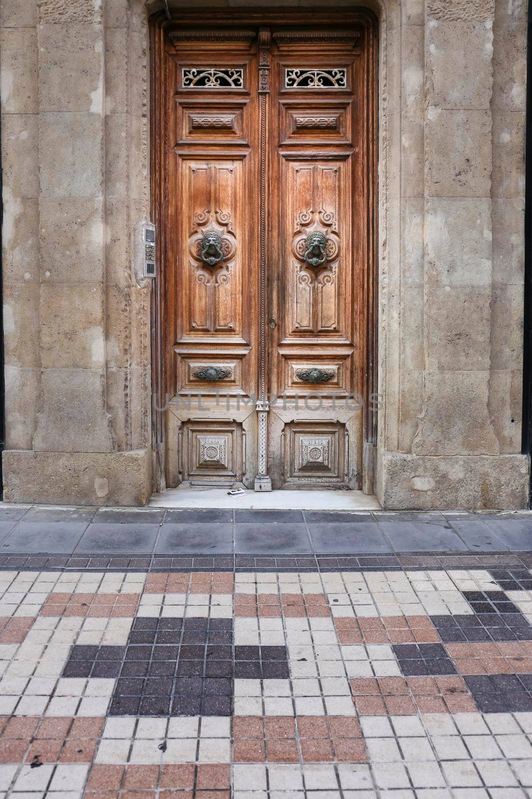 Old wooden door and vintage lion face shaped knocker in Spain