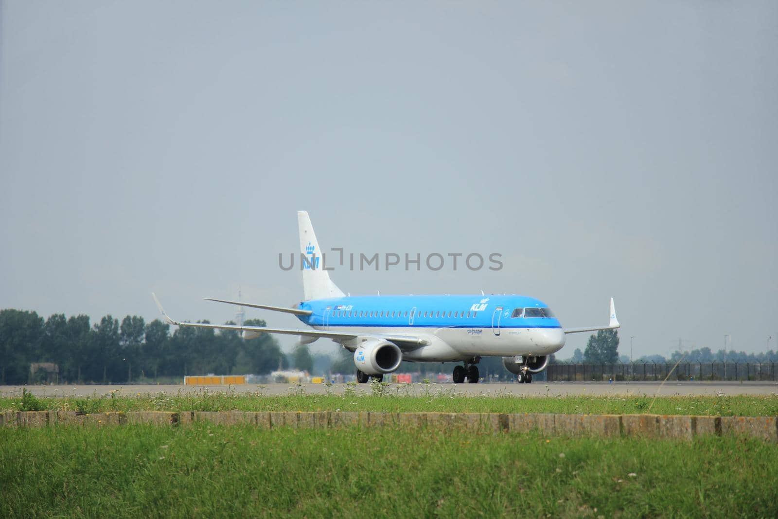 Amsterdam, The Netherlands - August 10 2015: PH-EZK KLM Cityhopper Embraer ERJ-190 taxing on the Polderbaan runway to the main terminal of Amsterdam Schiphol Airport