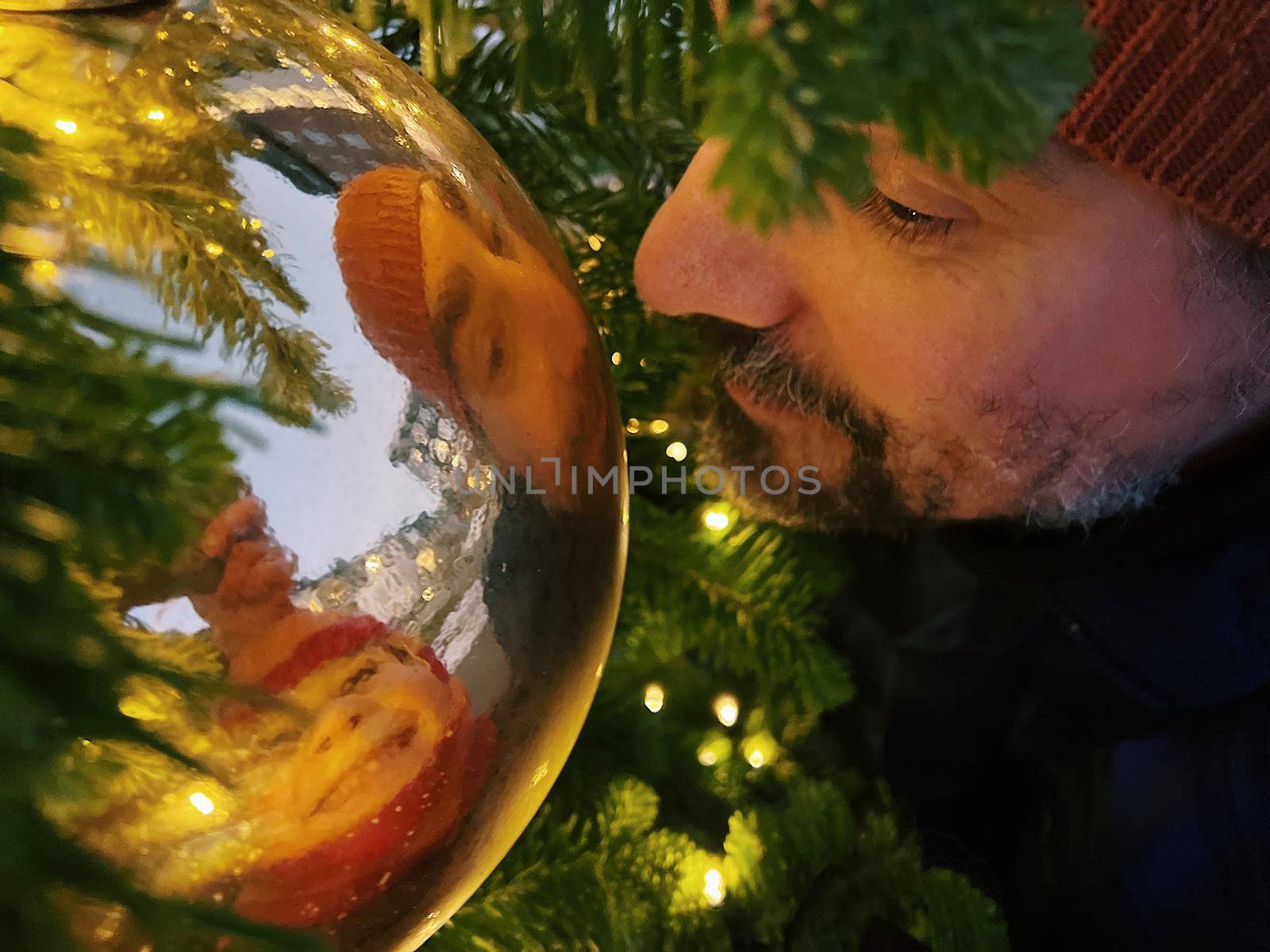 Close-up of a father and kid looking into a Christmas ball by Varaksina