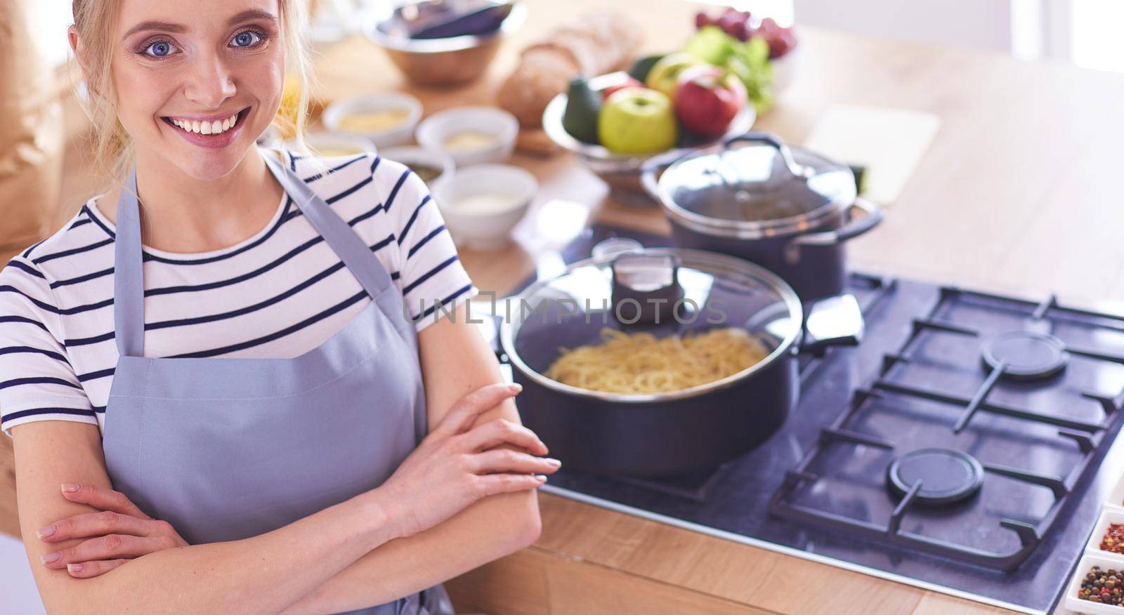 Young woman standing near desk in the kitchen .