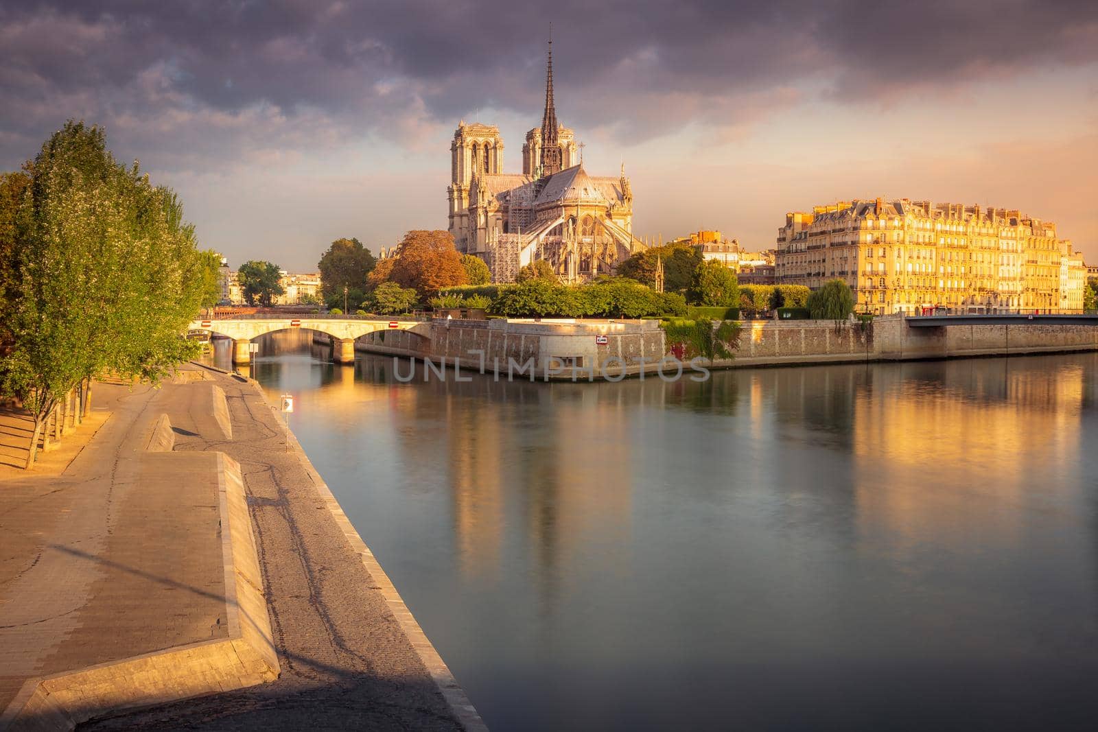 Notre Dame of Paris on Seine River reflection at peaceful sunrise, France