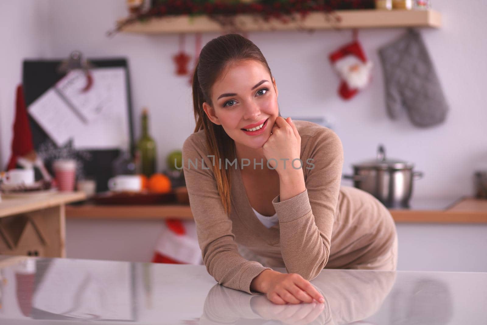 Smiling woman in the kitchen, isolated on christmas background