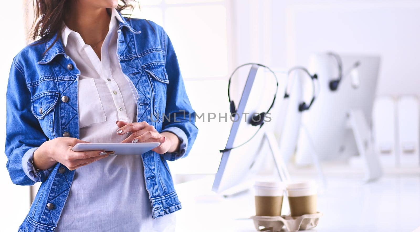 Smiling woman drinking coffee and using tablet in the cafe