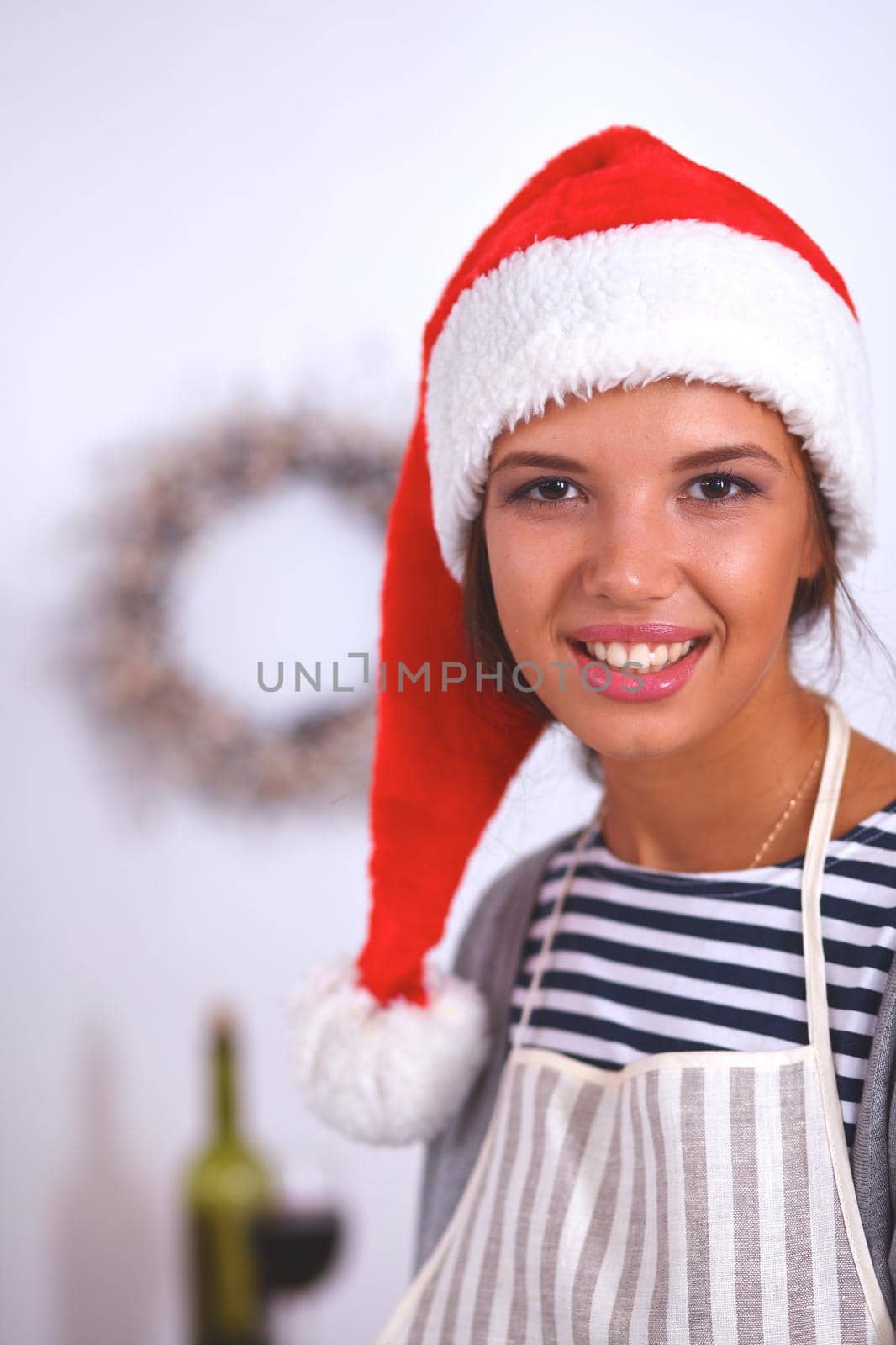 Christmas baking santa woman smiling happy having fun with Christmas preparations wearing Santa hat