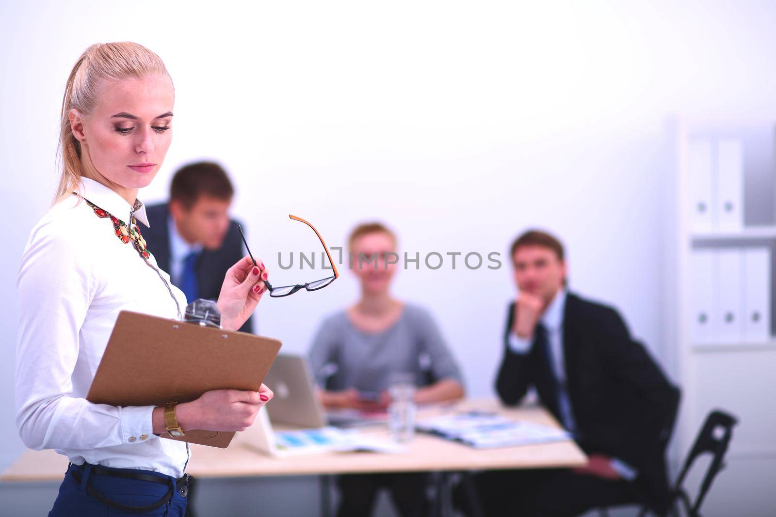 Portrait of a young woman working at office standing with folder . Portrait of a young woman. Business woman.