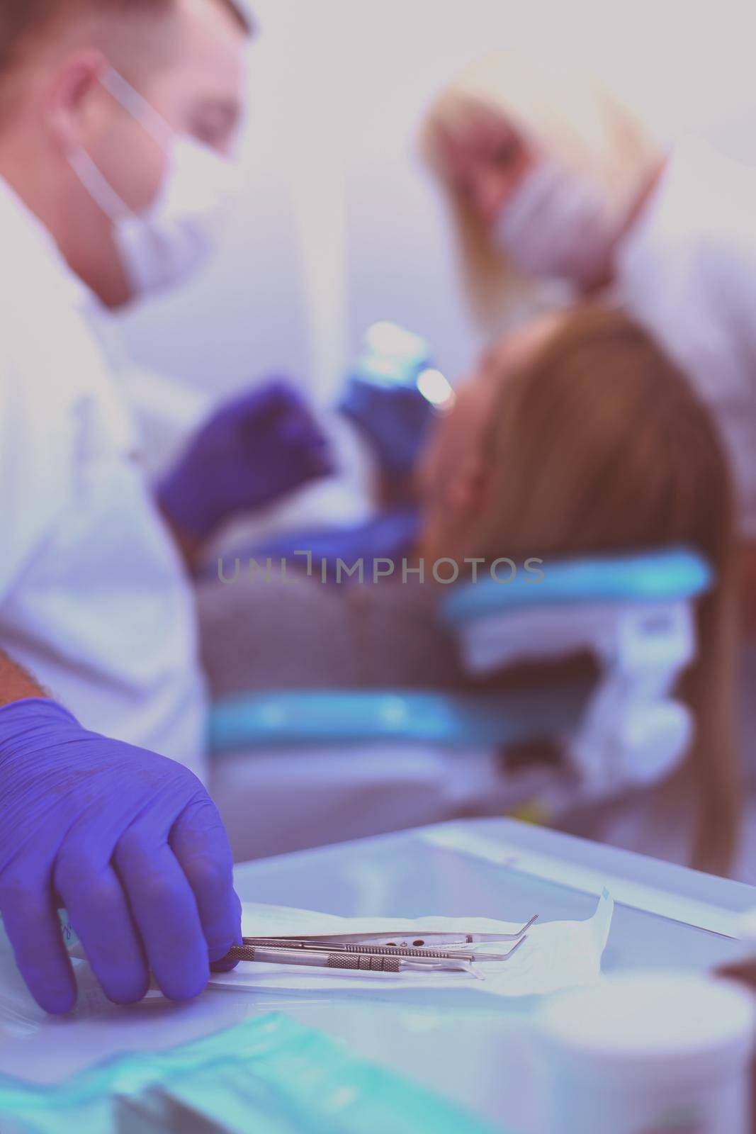 Detail of hand holding dental tools in dental clinic. Dentist Concept by lenets