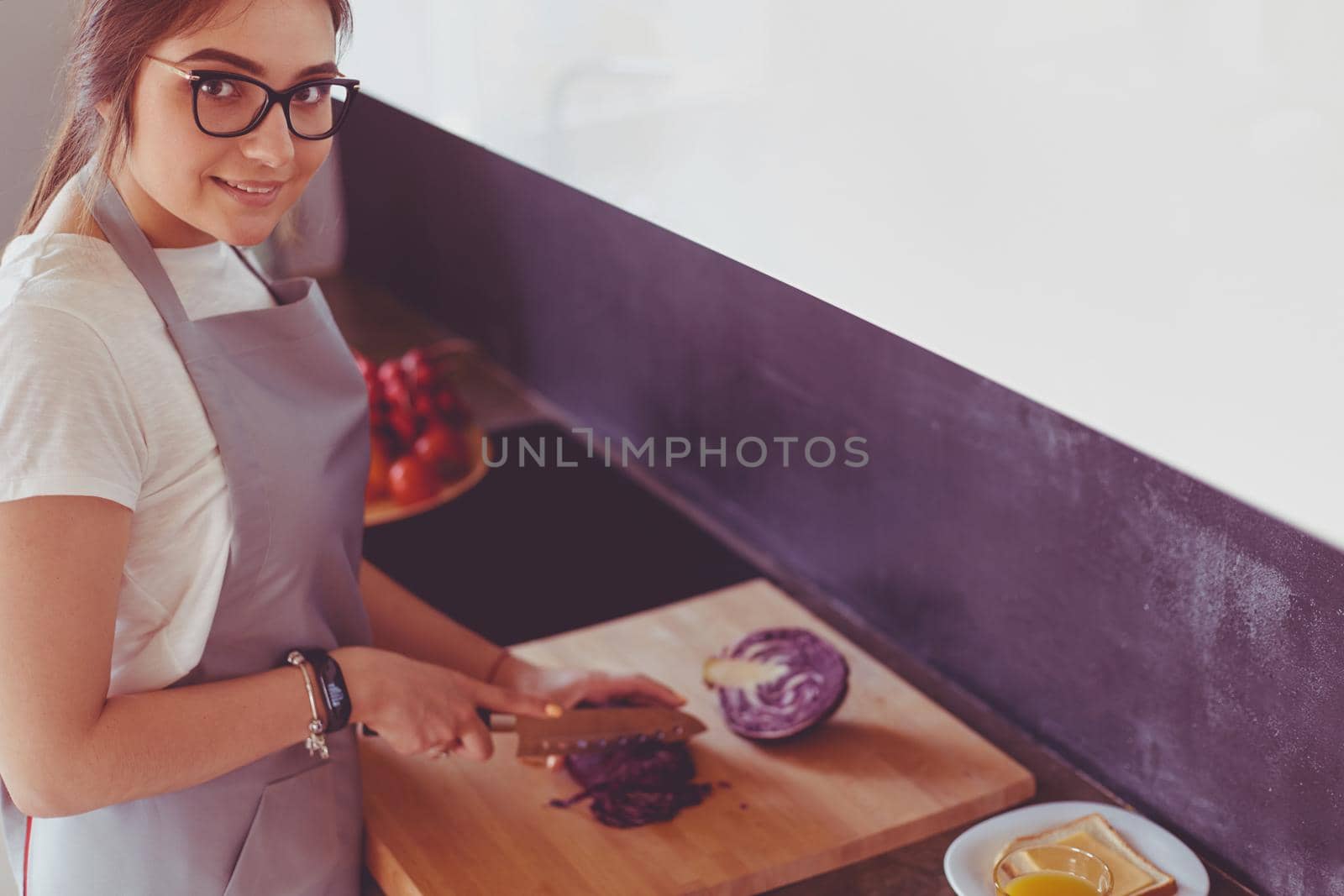 Young woman using a tablet computer to cook in her kitchen.