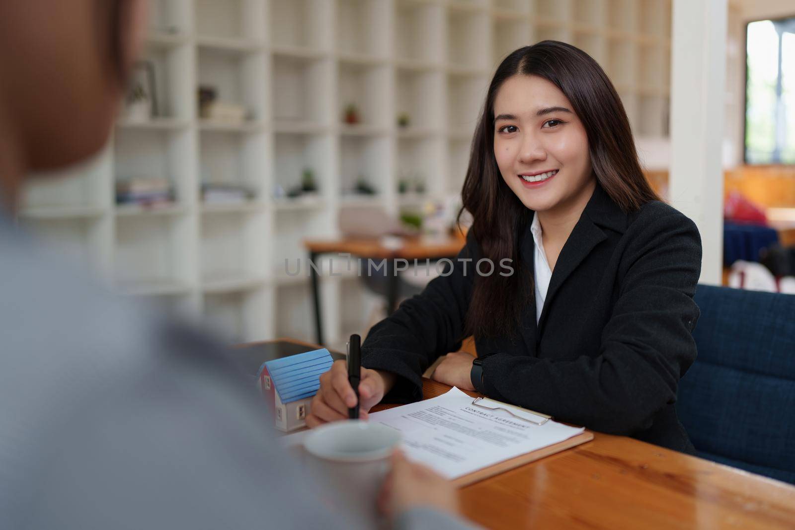 Business woman or Real Estate agent signing agreement for buying house. Bank manager and real estate concept