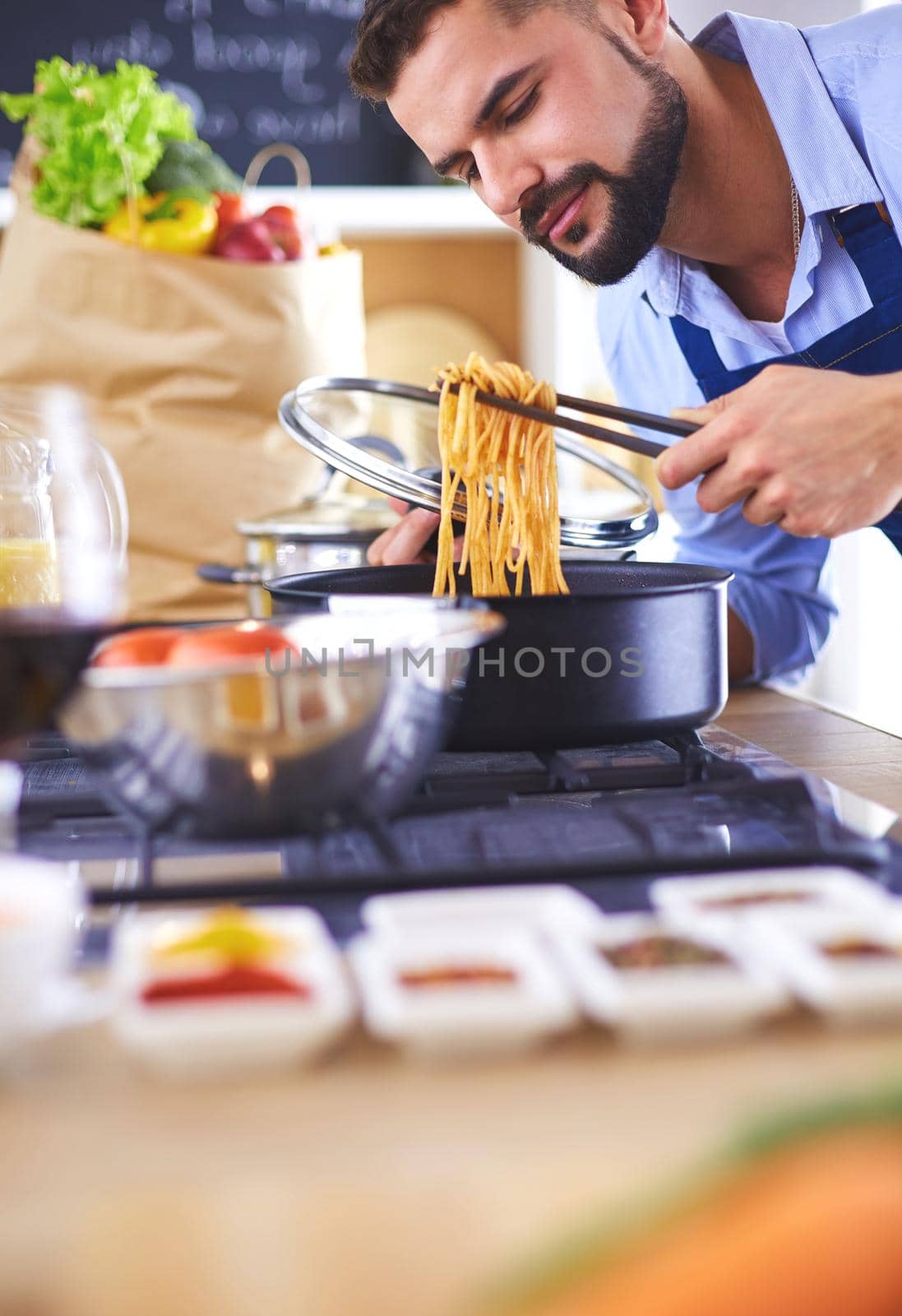 Man preparing delicious and healthy food in the home kitchen by lenets