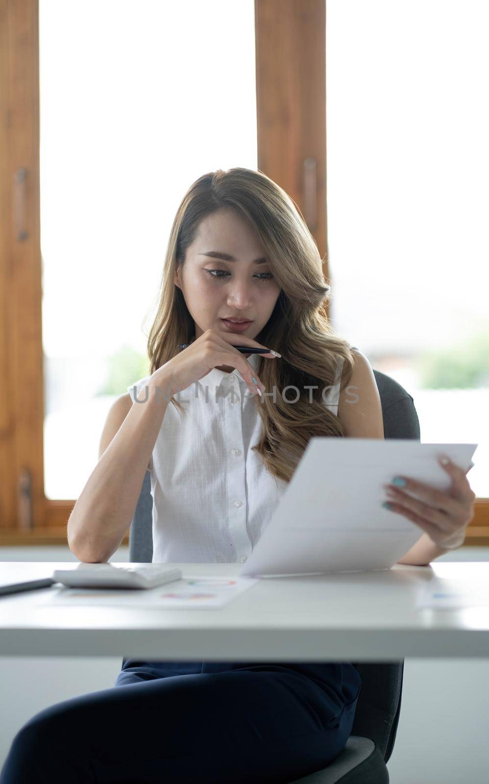 Portrait of Asian young female working on laptop at office by wichayada