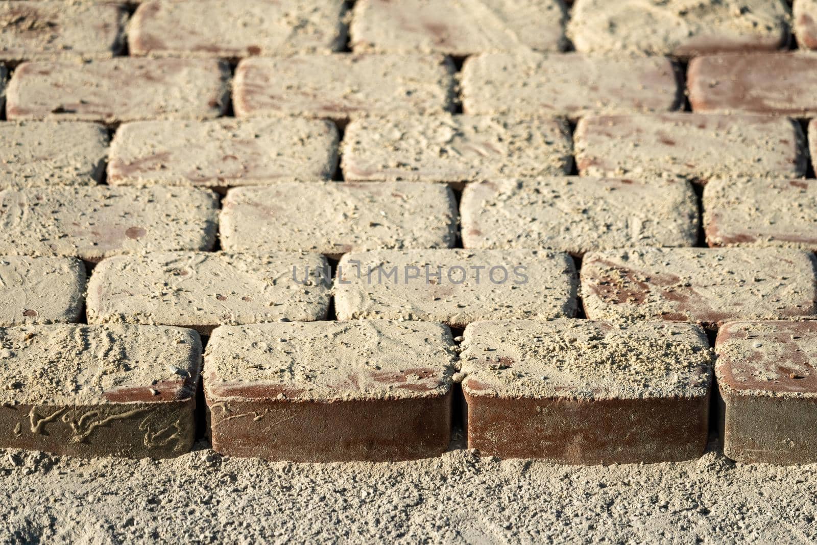 Brown concrete permeable flooring assembled on a substrate of sand. Abstract photo of bricks in the sunlight by panophotograph