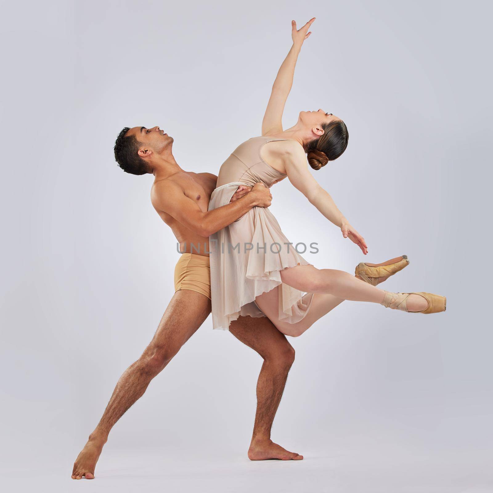 We dont need words to say how we feel. Studio shot of a young man and woman performing a ballet recital against a grey background. by YuriArcurs