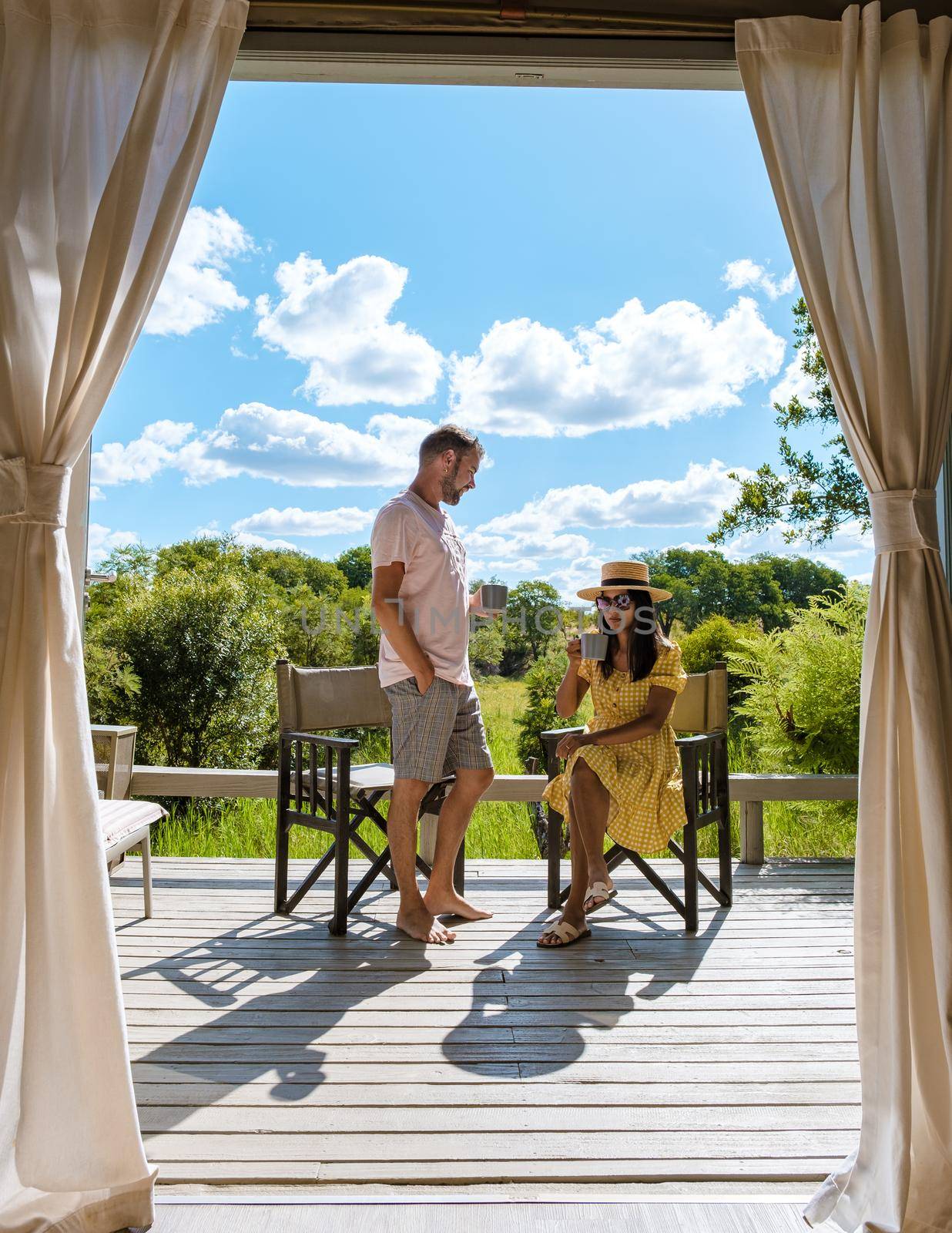 couple on safari in South Africa, Asian women and European men at a tented camp lodge during safari by fokkebok