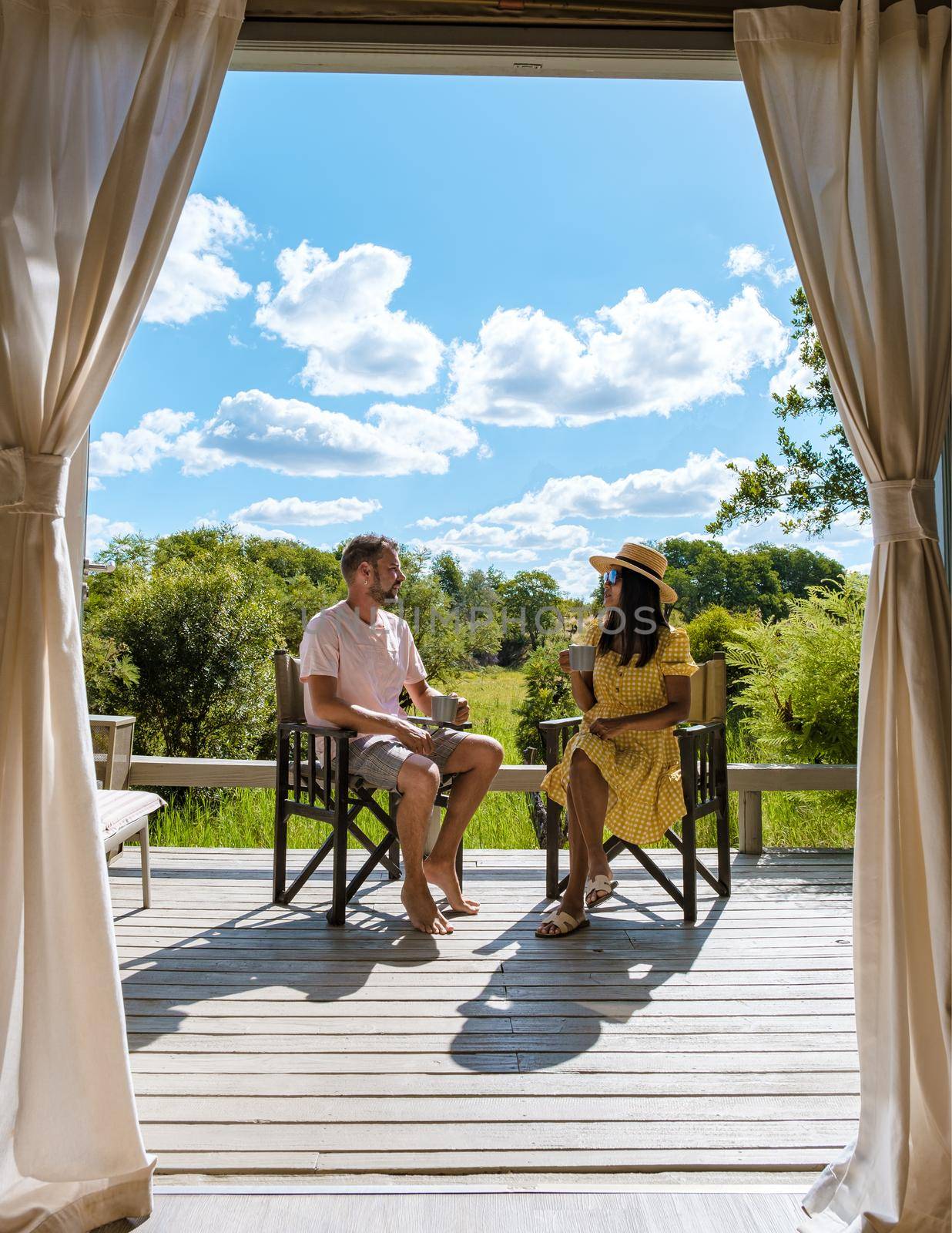 couple on safari in South Africa, Asian women and European men at a tented camp lodge during safari by fokkebok