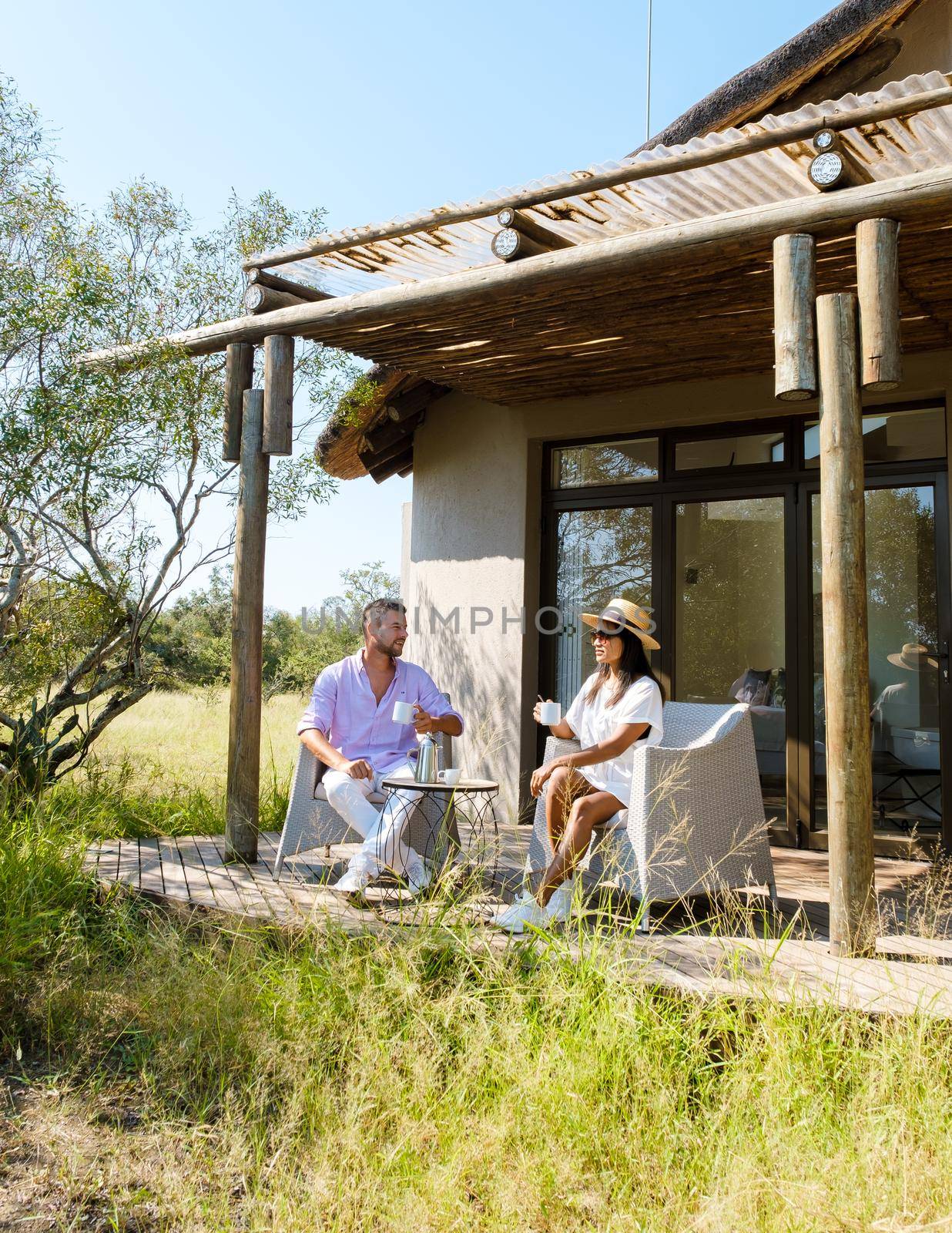 couple on safari in South Africa, Asian women and European men at a tented camp lodge during the safari. Couple of men and a woman are on vacation in South Africa