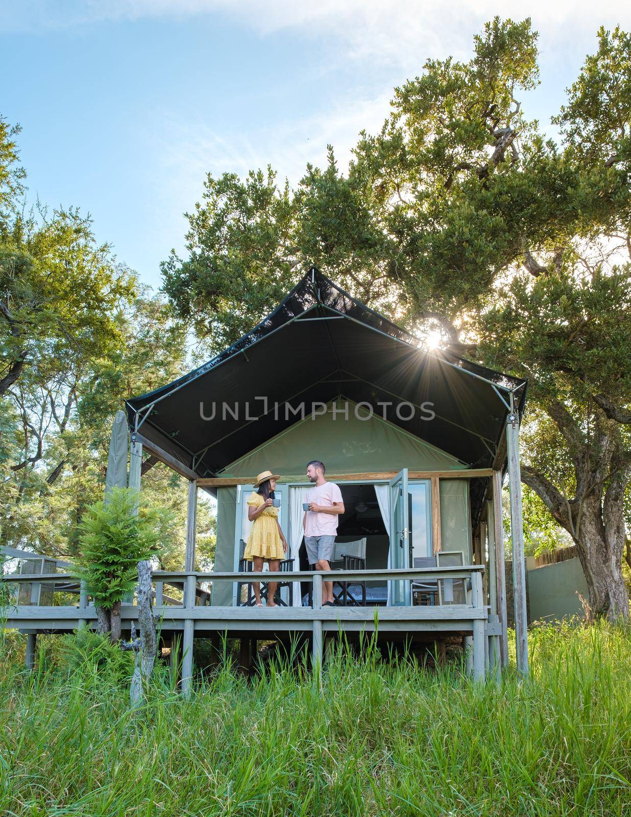 couple on safari in South Africa, Asian women and European men at a tented camp lodge during the safari. Couple of men and a woman are on vacation in South Africa