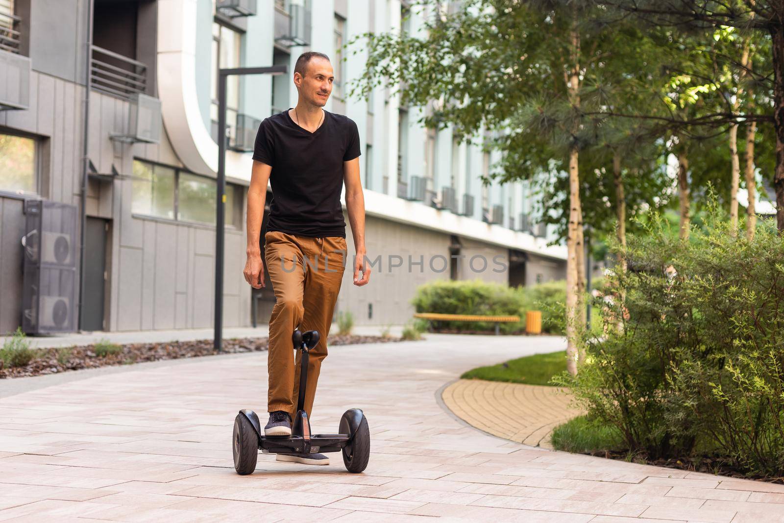 Man riding hoverboard, city. Guy on blue gyroboard.