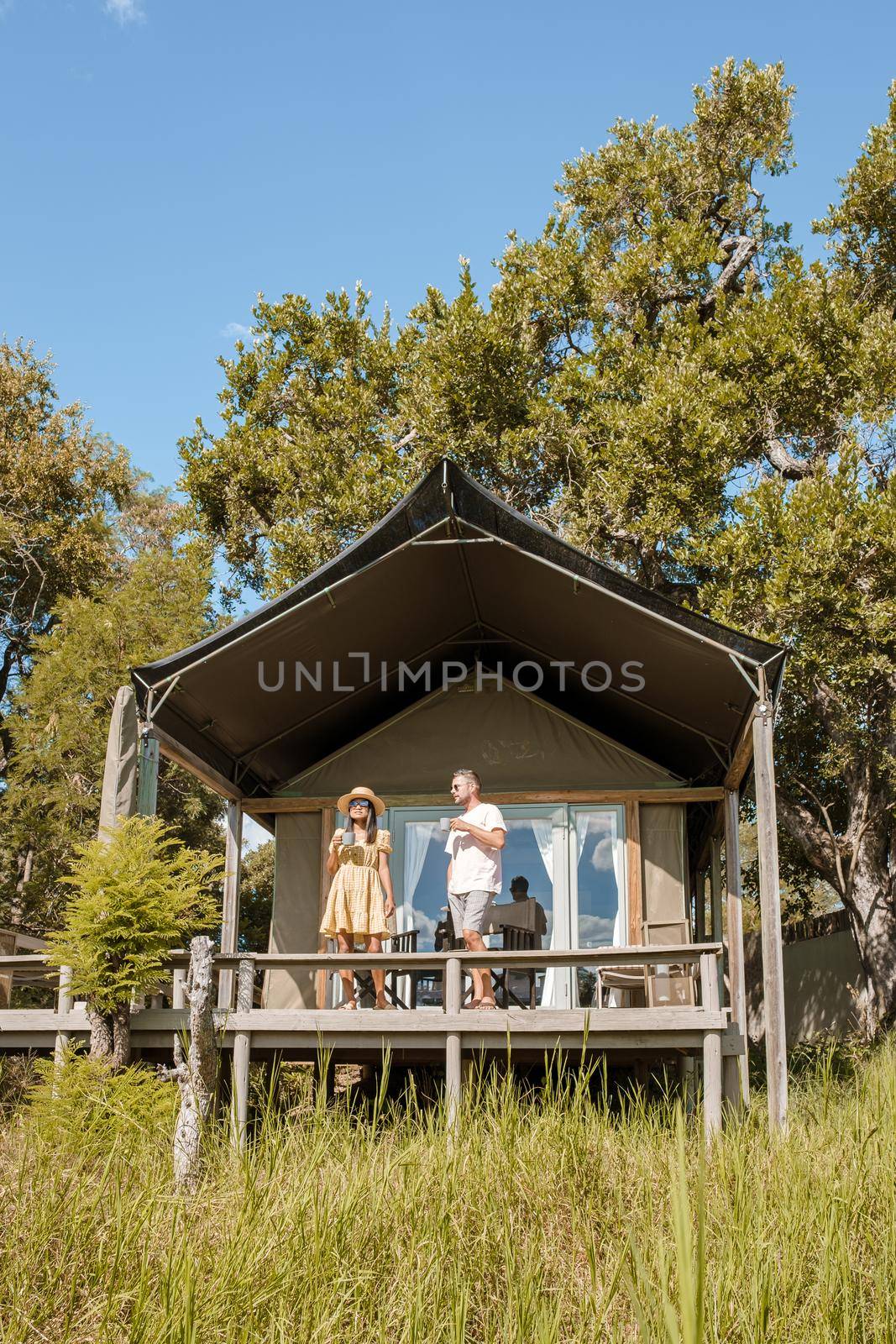 couple on safari in South Africa, Asian women and European men at a tented camp lodge during safari by fokkebok