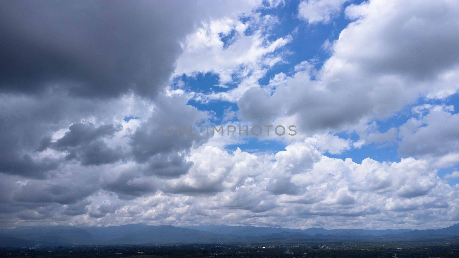 Aerial view of the blue sky with white clouds in summer day. Nature sky background. Aerial photograph from a drone.