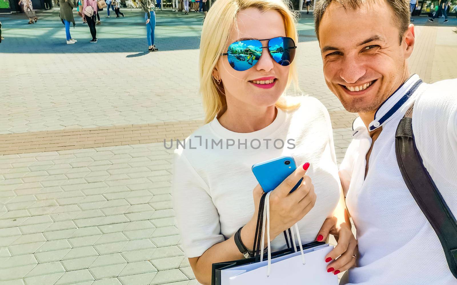 summer holidays, technology, love, relationship and dating concept - smiling couple taking selfie with smartphone in the city by Andelov13