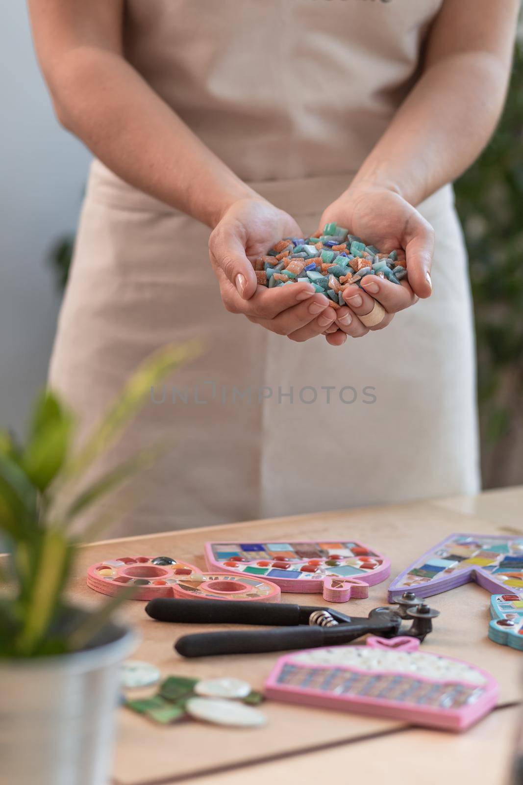 Workplace of the mosaic master: women's hands holding mosaic details in the process of making a mosaic by nazarovsergey