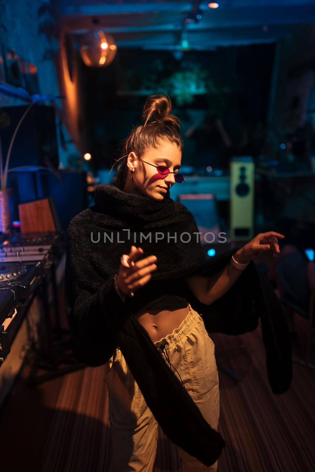 Beautiful female DJ dancing to techno